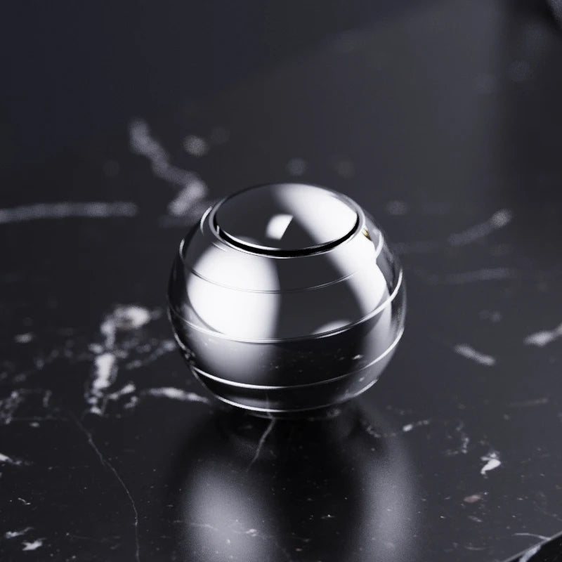 A silver metal fidget spinner resting on a dark, reflective surface.