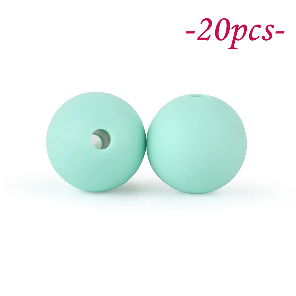 Two light mint green silicone beads, one with a hole, are shown against a white background.