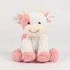 A soft, cuddly cow plush toy with white and pink fur, featuring a smiling face.