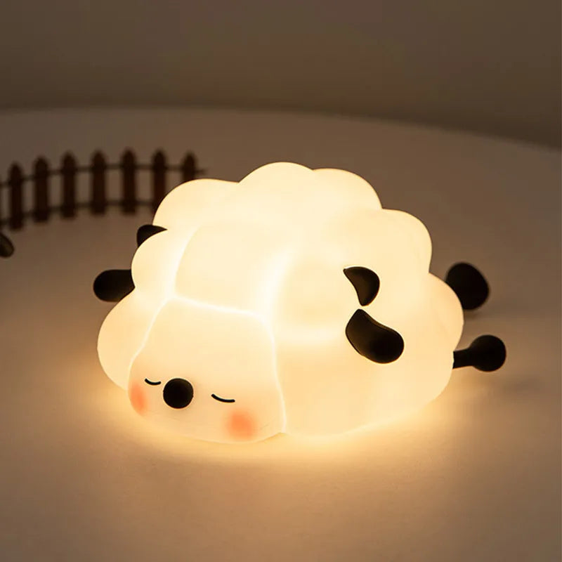 A glowing white silicone rabbit night light with closed eyes and small ears resting on a surface.