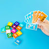 A hand holds a stack of orange cards showing finger counting and several wooden blocks with numbers 0 through 8.