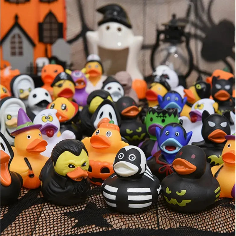 A collection of Halloween pumpkin rubber ducks in various colors and sizes displayed on a black mesh surface.