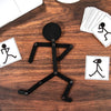 A black wooden jigsaw puzzle depicting a running figure, used as an early learning toy.