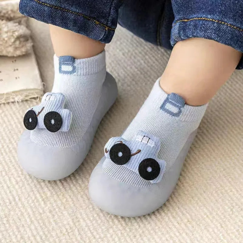 A pair of light blue soft sole sock shoes for babies and toddlers with animal designs