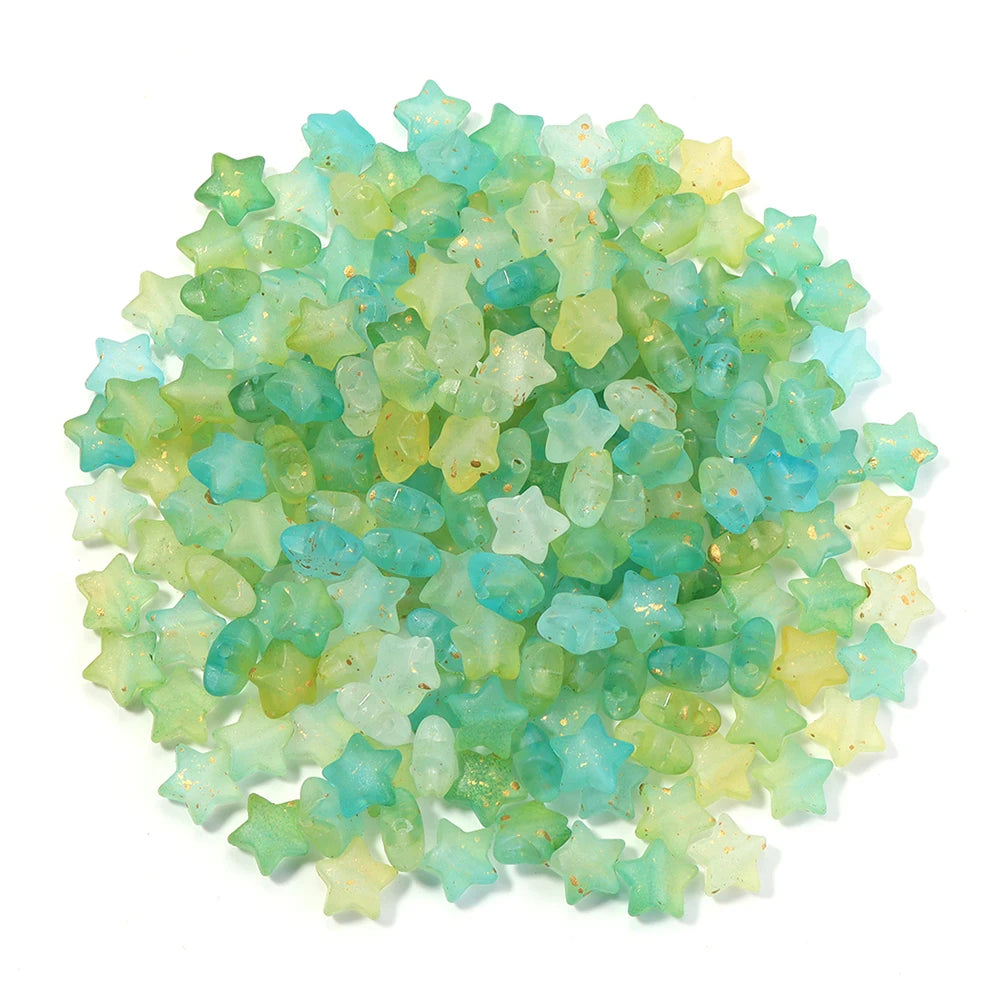 A pile of colorful transparent star acrylic beads in shades of green and blue.