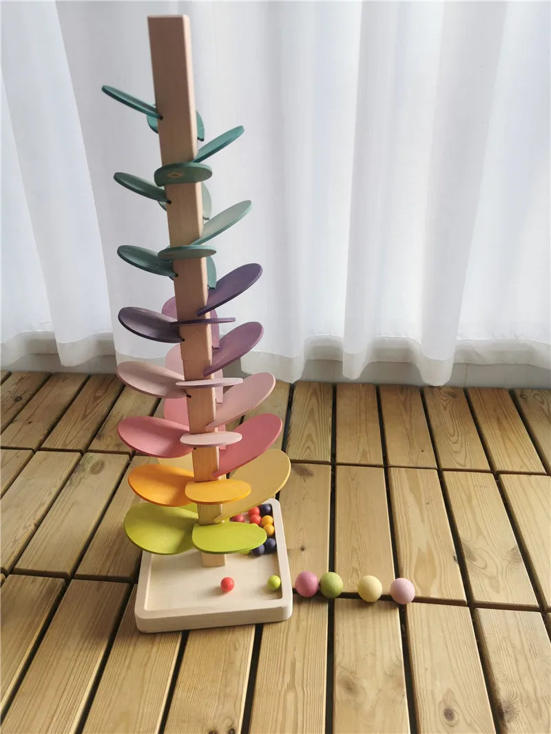 A wooden sensory music tree with a marble run featuring colorful, layered leaves.