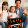 A man and two girls smiling while holding a box labeled muscle car 2025 event.
