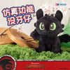 A black Toothless Dragon plush toy with movable wings and glowing green eyes sitting on green moss.