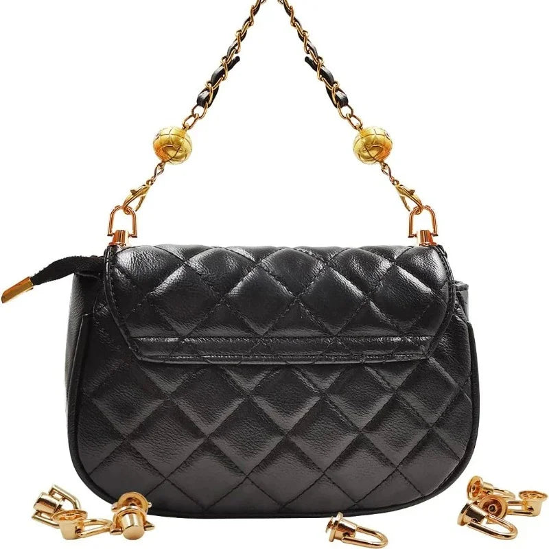 Black quilted leather bag with gold metal D-ring buckle clips hanging from the strap