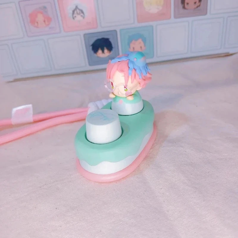 A collectible keycap blind box featuring a small figure with pink and blue hair on a light green base.
