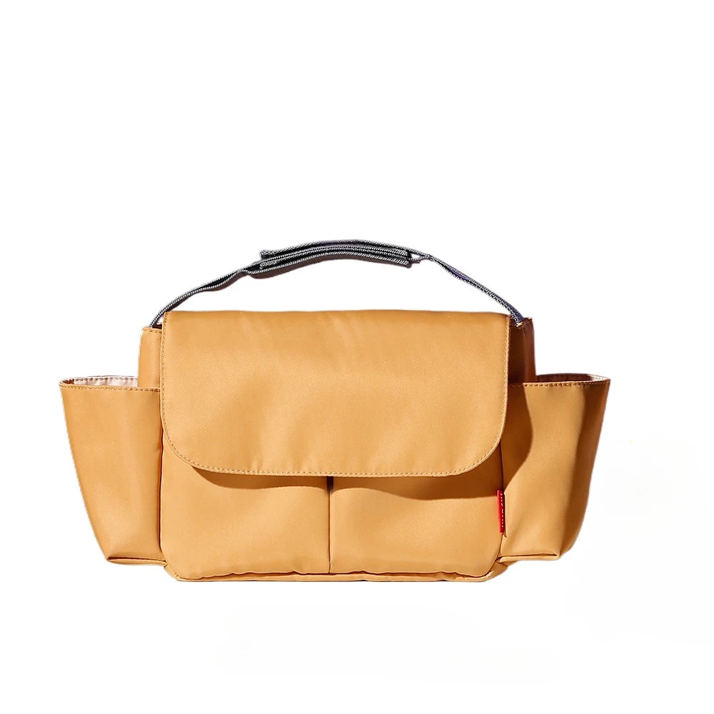 A tan large capacity stroller organizer bag with a black adjustable strap.