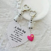 A set of three heart-shaped keychains featuring penguins and a pink heart on a white background.