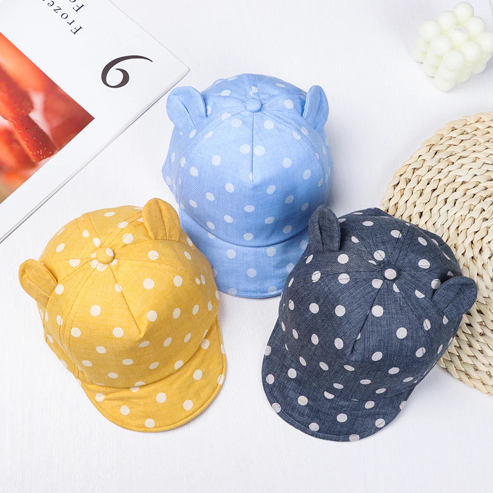 Three baby cotton baseball caps in blue and yellow with rabbit ears displayed on a white background.