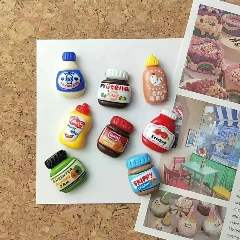 A set of eight kawaii jam jar fridge magnets featuring various fruit and food themes.