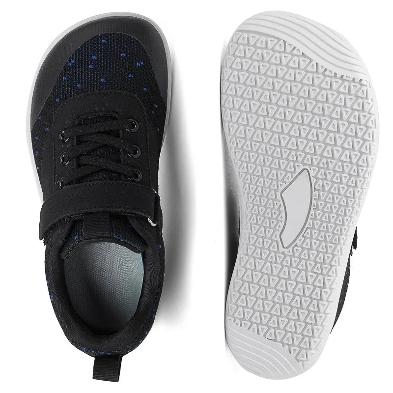 Side view of black and white minimalist barefoot sneakers with a wide toe box