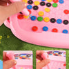 A pink magnetic doodle board for kids showing a hand pressing beads onto a surface.