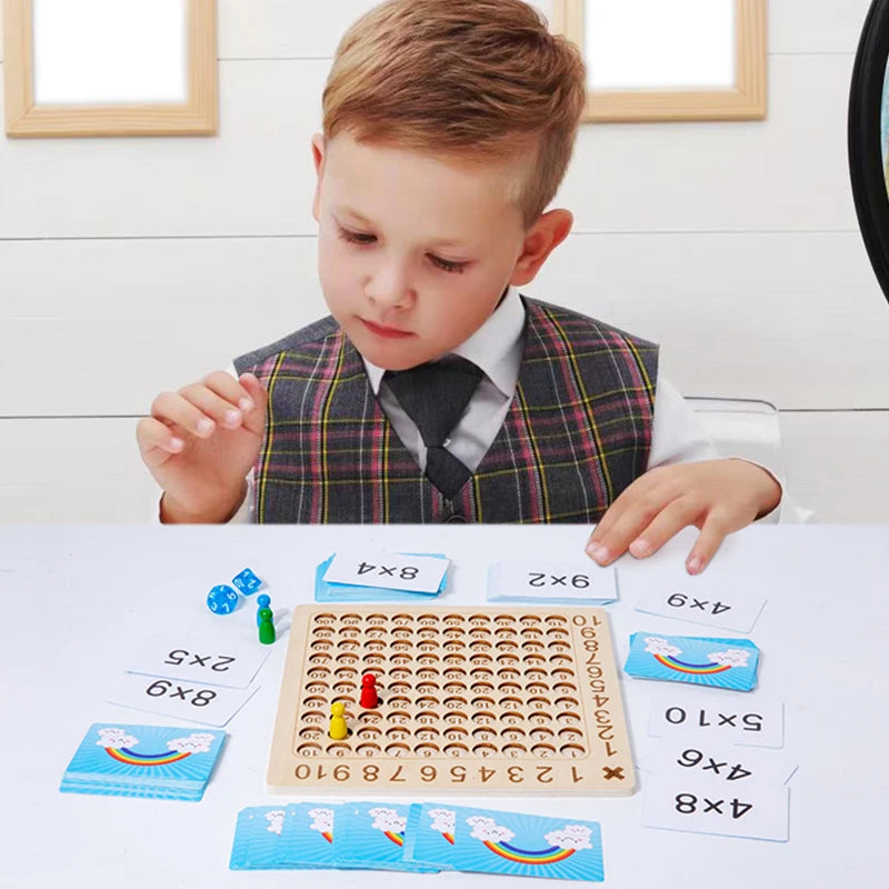 A child is looking at a wooden multiplication board game with numbered tiles and cards on a white table.