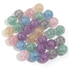 A collection of round loose glitter cracked acrylic beads in various shades of pink, purple, green, and blue.