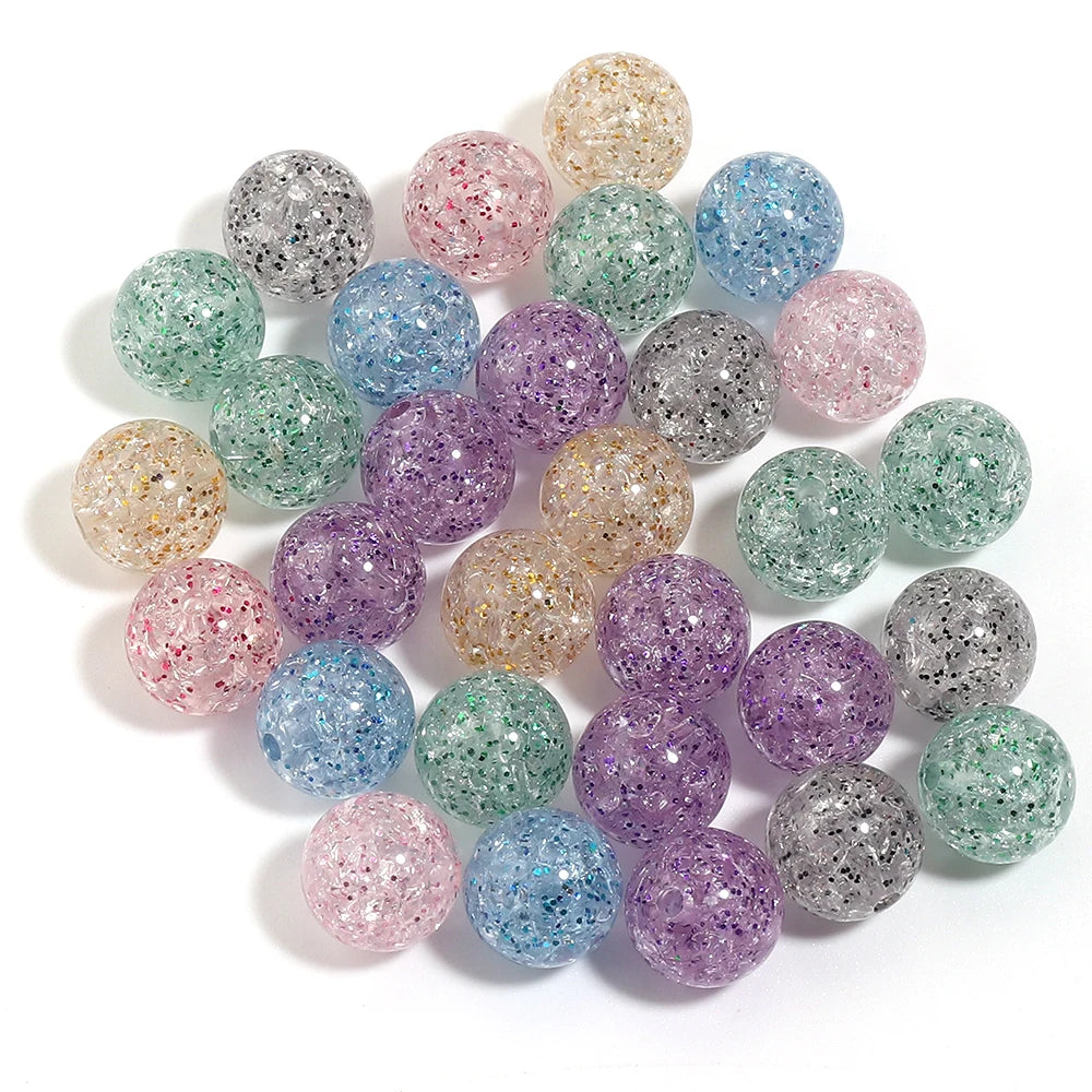 A collection of round loose glitter cracked acrylic beads in various shades of pink, purple, green, and blue.