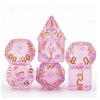 A set of seven pink glitter translucent polyhedral dice, including a pyramid and various geometric shapes.