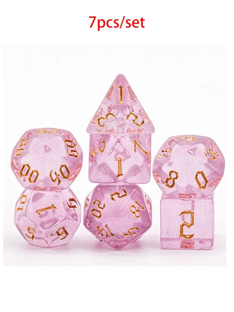 A set of seven pink glitter translucent polyhedral dice, including a pyramid and various geometric shapes.