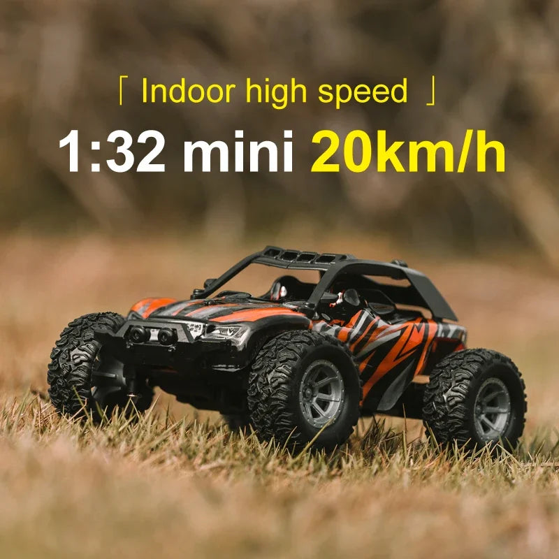 An orange and black 1:32 scale RC off-road car is shown driving through dry grass.