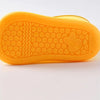 An orange, flexible silicone rain boot sole with a textured pattern and a molded foot shape.