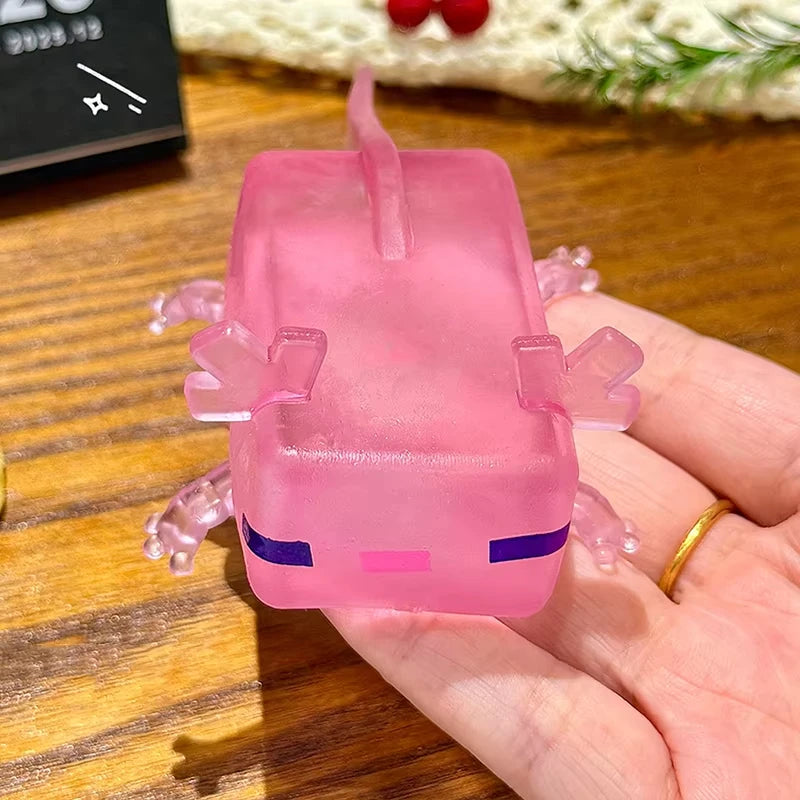 A pink squishy fidget toy shaped like a small creature with purple accents is held in a hand.