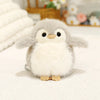 A fluffy gray and white cartoon bird plush keychain with large eyes resting on a white surface.