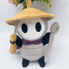 A soft plush doll resembling a character with a straw hat and purple accents.