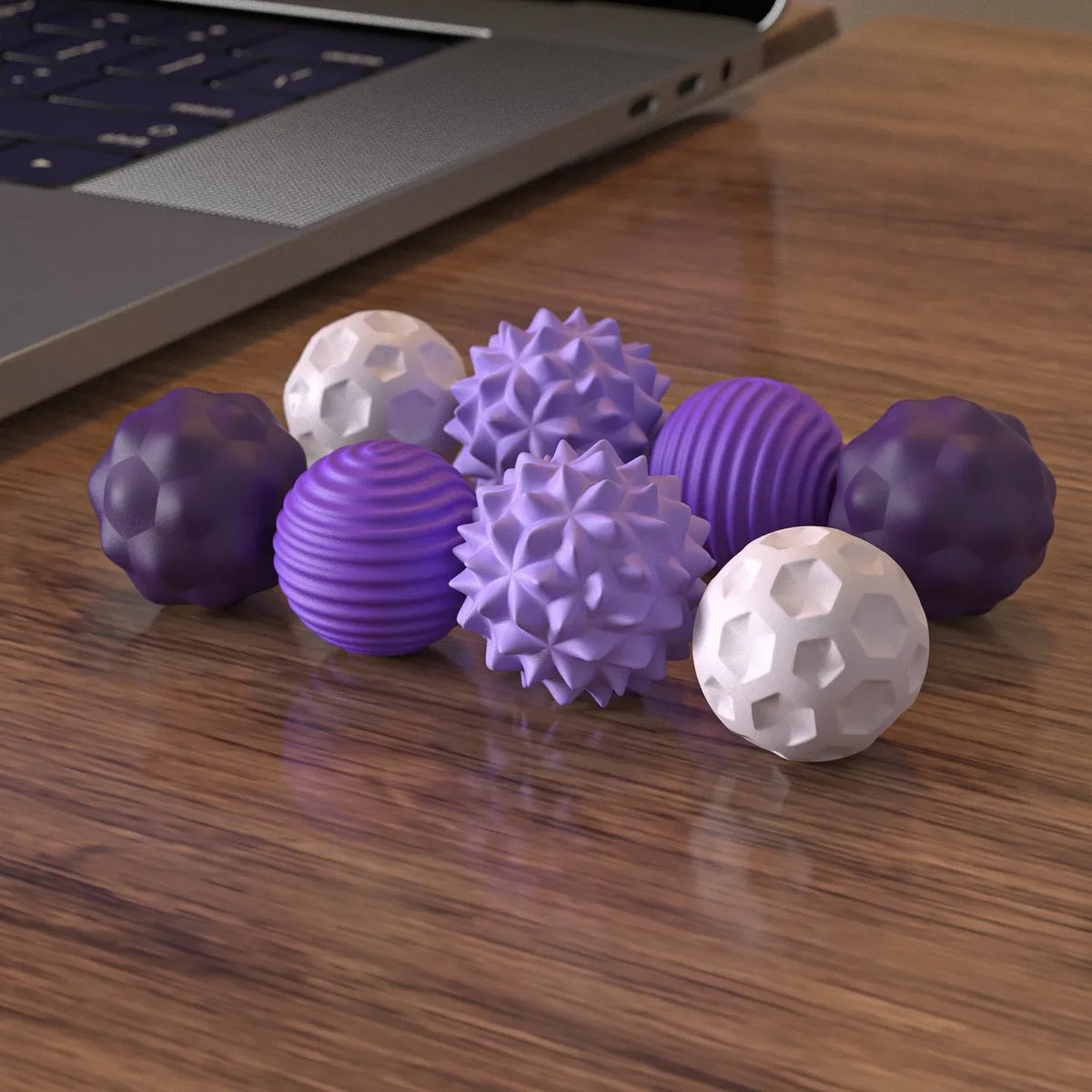 Eine Sammlung lila und weiße silikonische magnetische Fidget-Bälle auf einer Holzoberfläche.