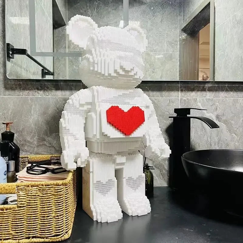 A white bear building block display model with a red heart cutout, placed on a dark countertop.