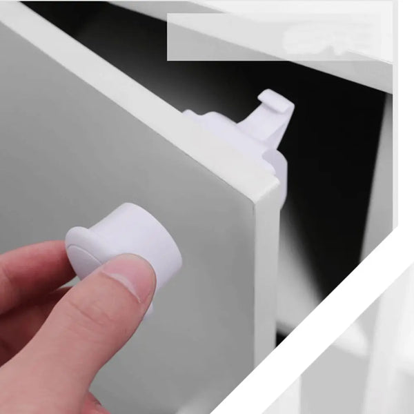 A hand is operating a white magnetic cabinet or drawer security lock.