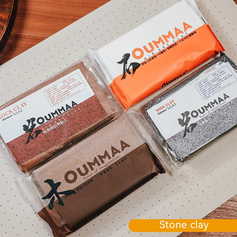 Pack of OUMMAA air-dry stone clay in various colors and packaging on a white surface.