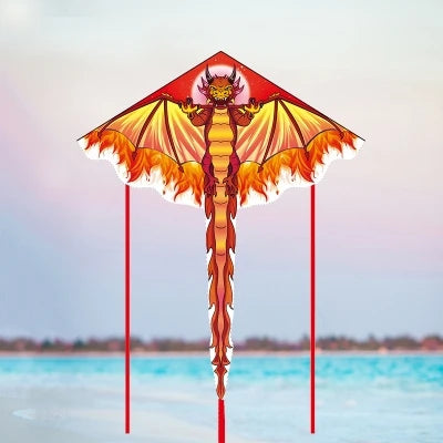 Un cerf-volant delta orange et jaune en forme de dragon, affiché contre un ciel doux et de l'eau bleue.