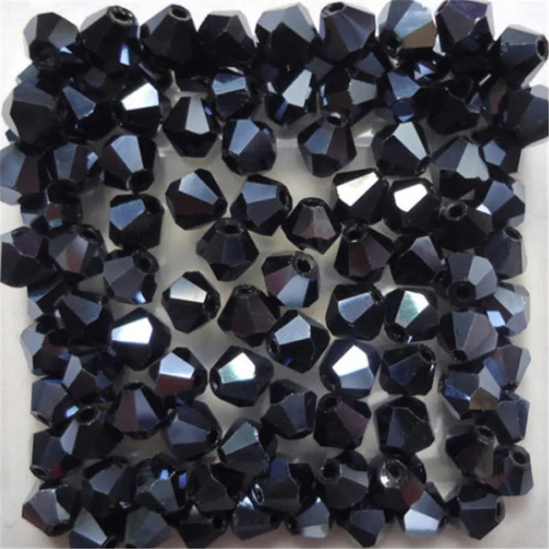 A collection of faceted black glass bicone beads for jewelry making.