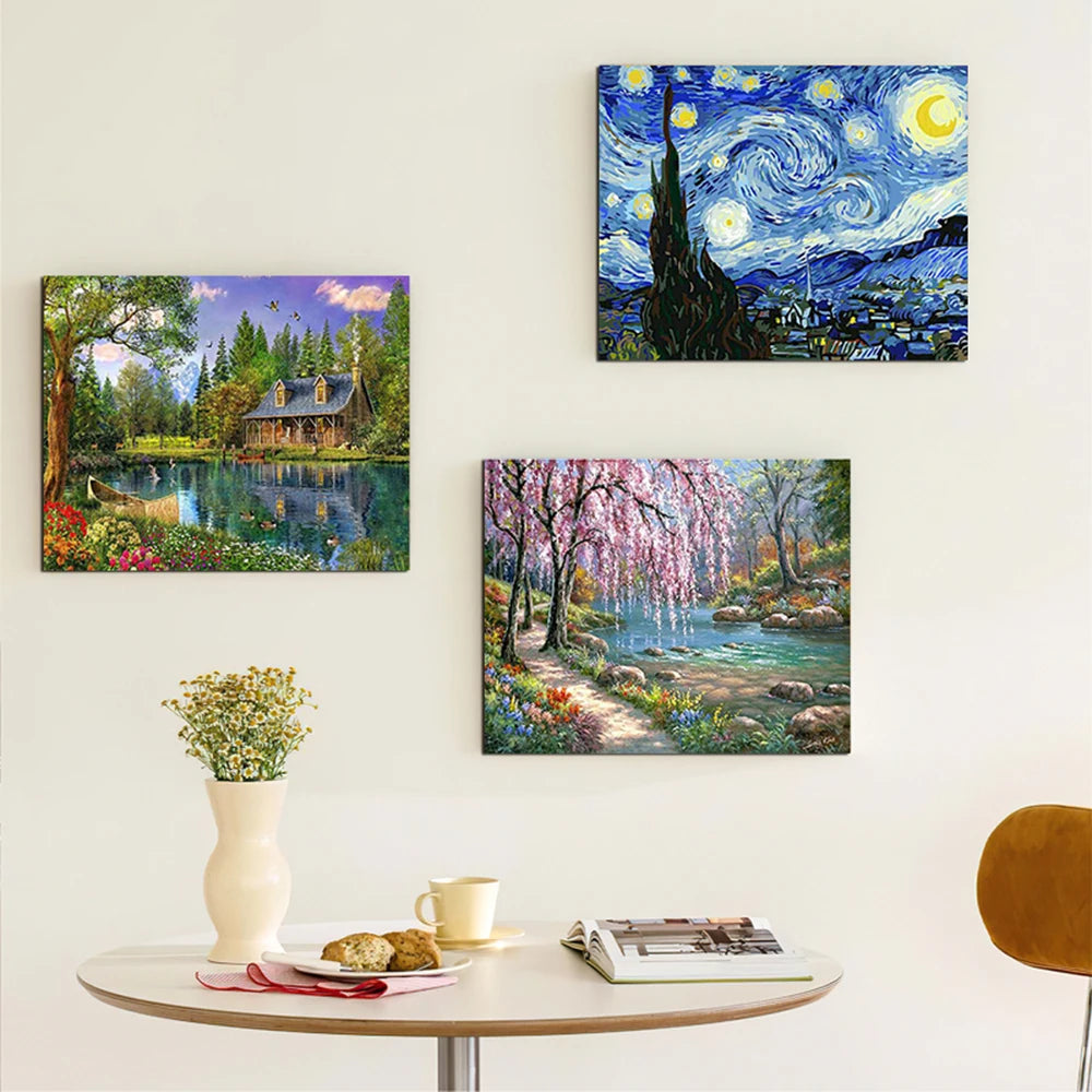 A collection of three oil paintings depicting landscapes and seascapes, displayed on a white wall above a table.