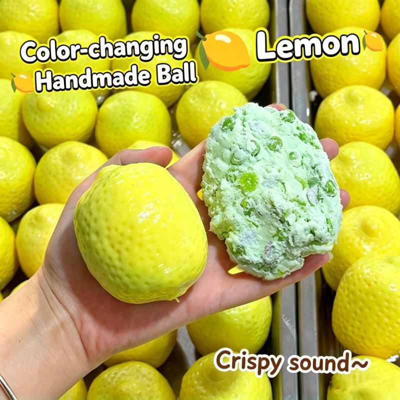 A hand holds a yellow lemon and a green handmade ball made from lemon, demonstrating the color-changing property.