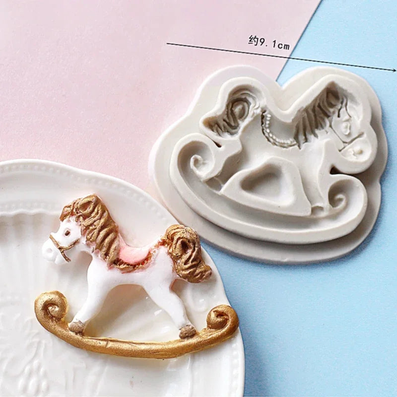 A set of white silicone cake molds featuring a horse design, including a larger mold and a smaller decorative piece.