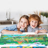 A parent and child are reading a reusable cartoon sticker book together with various colorful scenes.