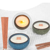 A set of cherry wood candle wicks with iron brackets and glue dots displayed on a white textile background.
