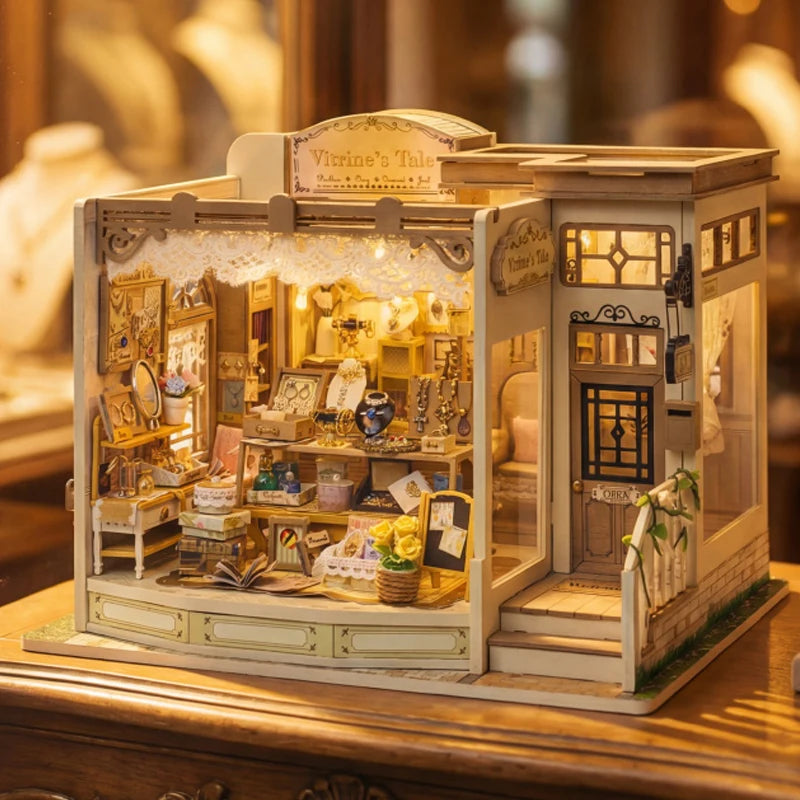 A detailed miniature dollhouse kit of a wooden jewelry store with glass display cases and LED lights.