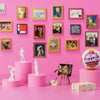 A display of Zuru Mini Brands Create Masterpieces series 5 blind balls in various frames and on pink pedestals.
