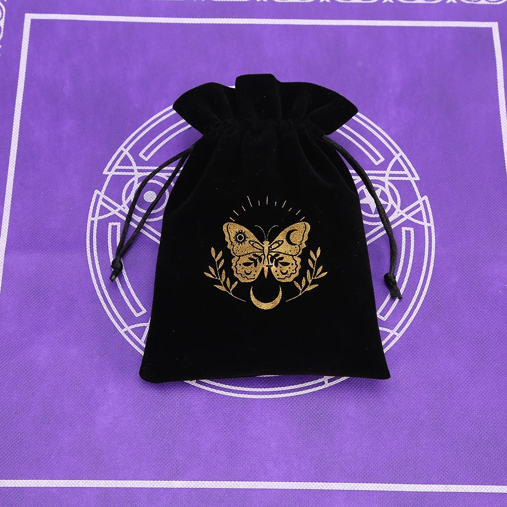 A black velvet tarot card pouch with a drawstring closure featuring a gold butterfly design on a purple background.