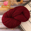 A ball of deep maroon yarn used for knitting or weaving, displayed on a wooden surface.