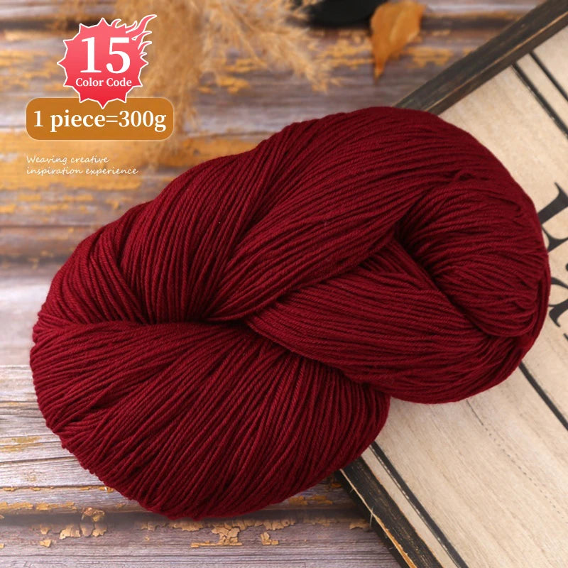 A ball of deep maroon yarn used for knitting or weaving, displayed on a wooden surface.