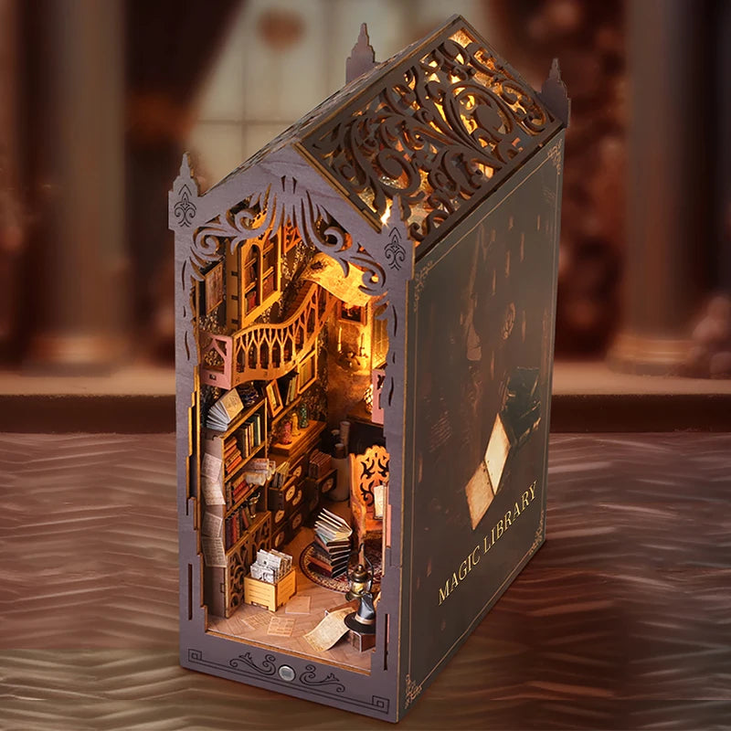 A detailed diorama of a magic library book nook kit featuring miniature furniture and architectural details.