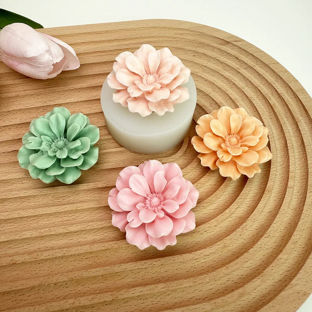A collection of pink and peach silicone flower molds shaped like carnations resting on a wooden surface.