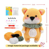 A yellow crocheted bear toy with pink ears and a complete set of crochet tools and yarn is displayed.