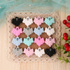 A set of five silicone ghost beads in various pastel colors including pink, blue, green, and white, displayed on a woven mat.